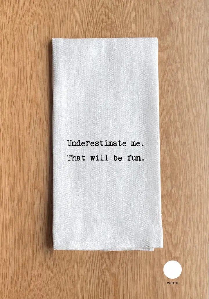 White folded paper note on wood table with blurry typed text.