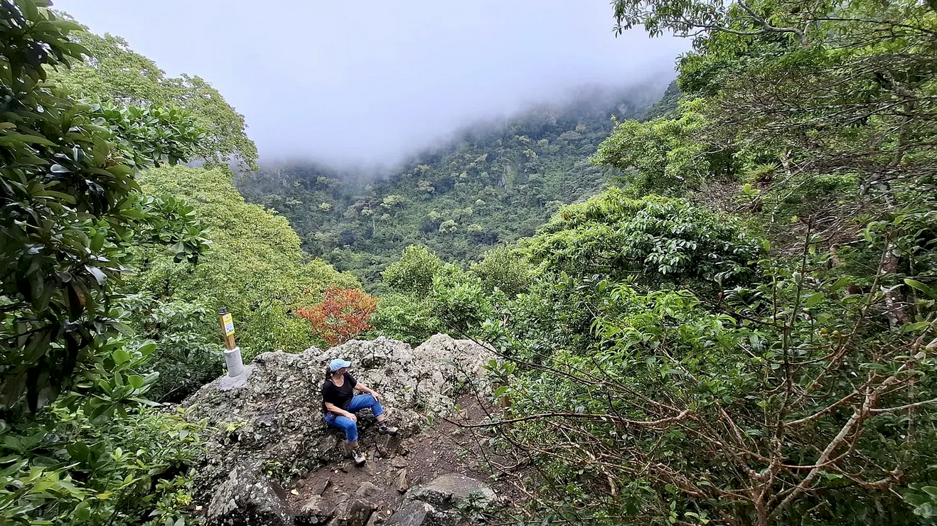 Photo of Françoise Vaal hiking a rugged landscape trail in The Quill on St. Eustatius.