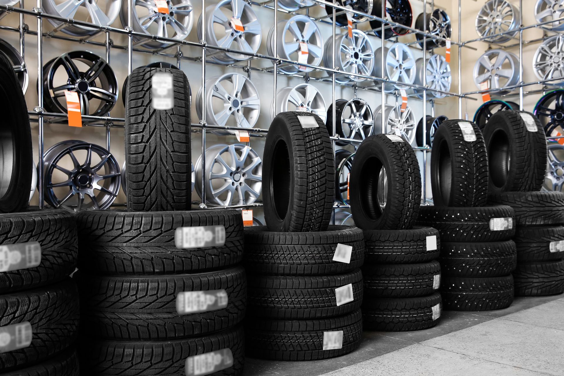 Car tires and alloy wheels at a tire shop.