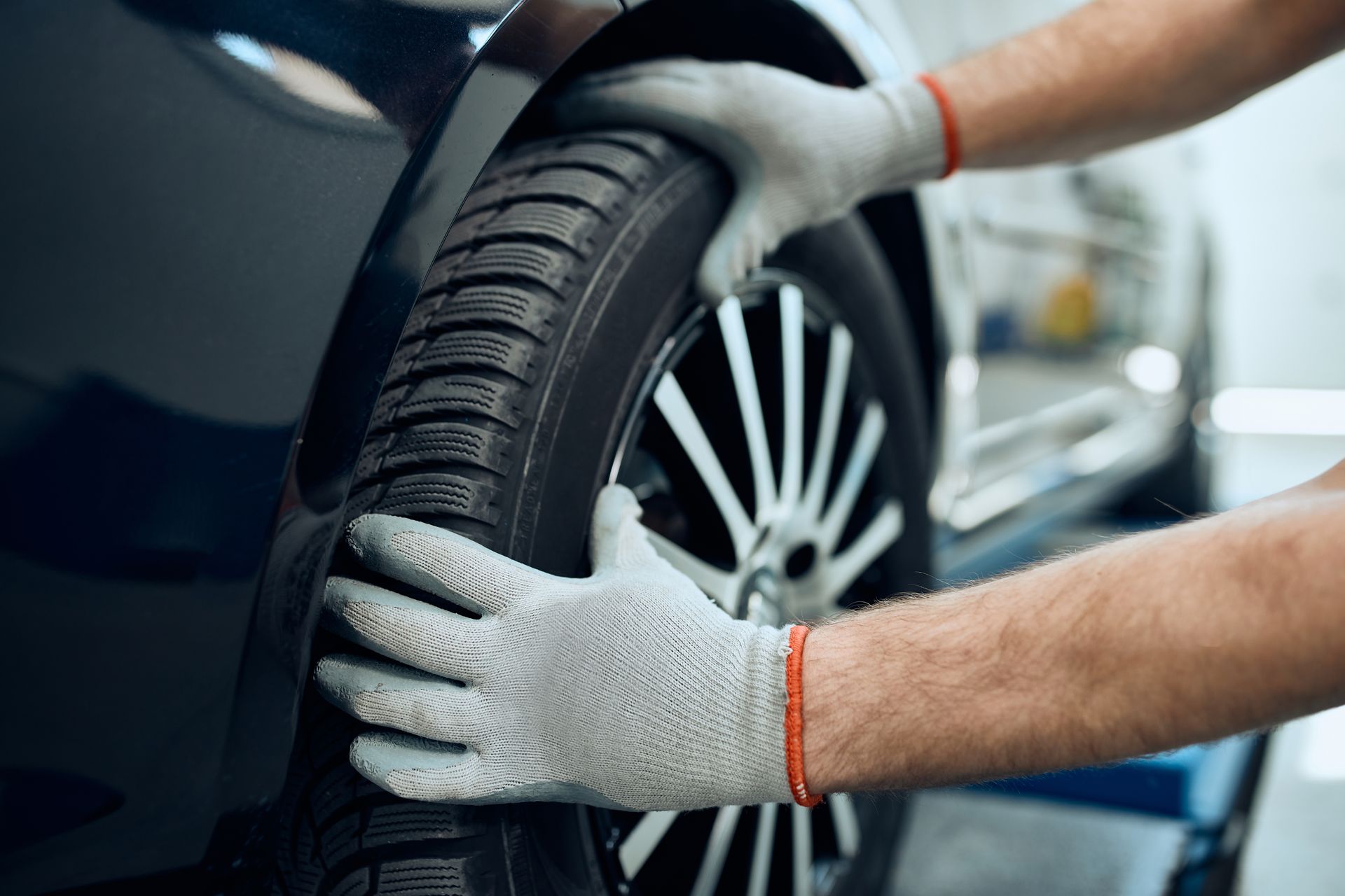 Close-up of a technician changing a tire at a shop providing reliable car repair services.