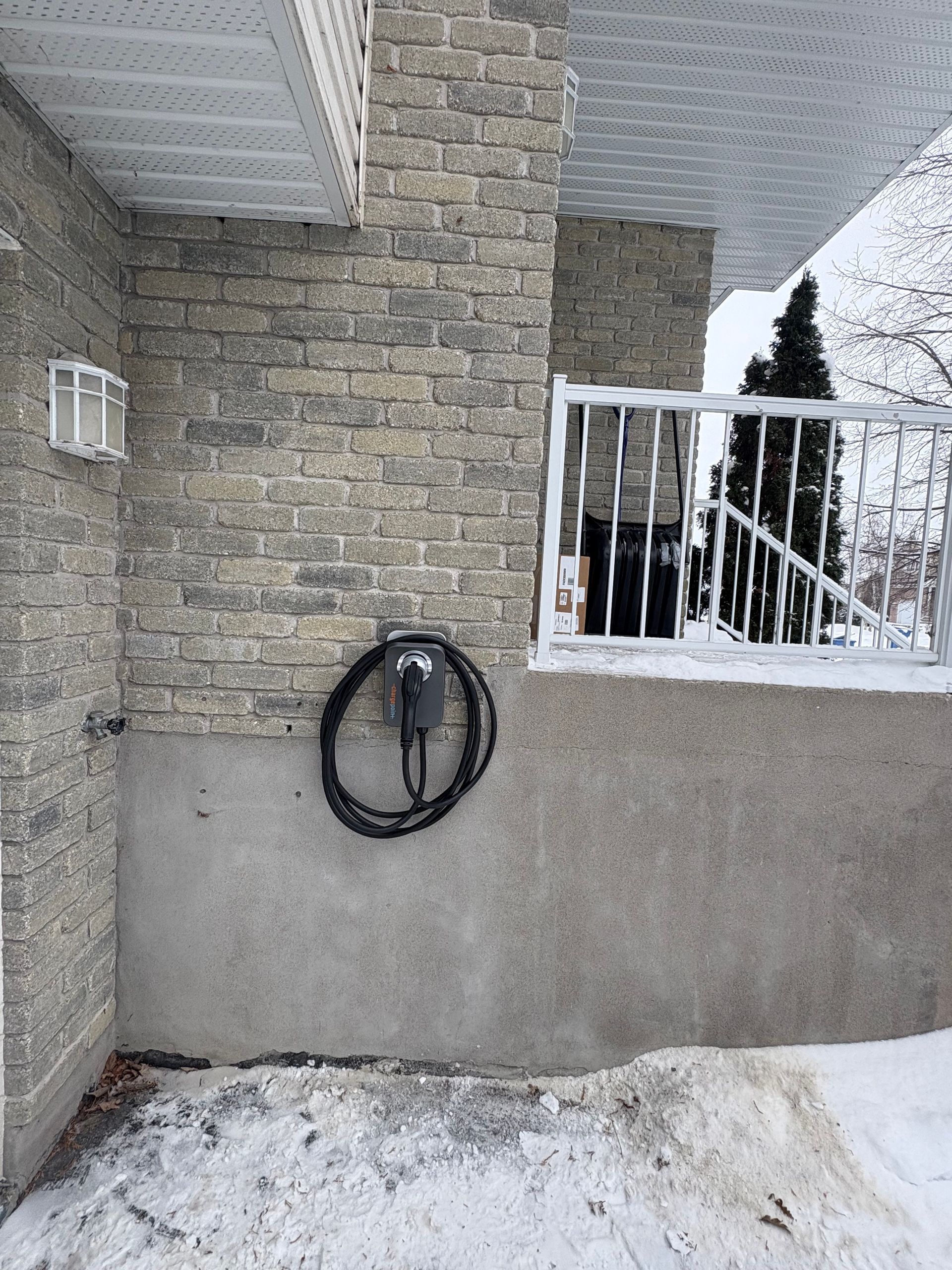 Un tuyau est suspendu sur le côté d'un bâtiment en briques.