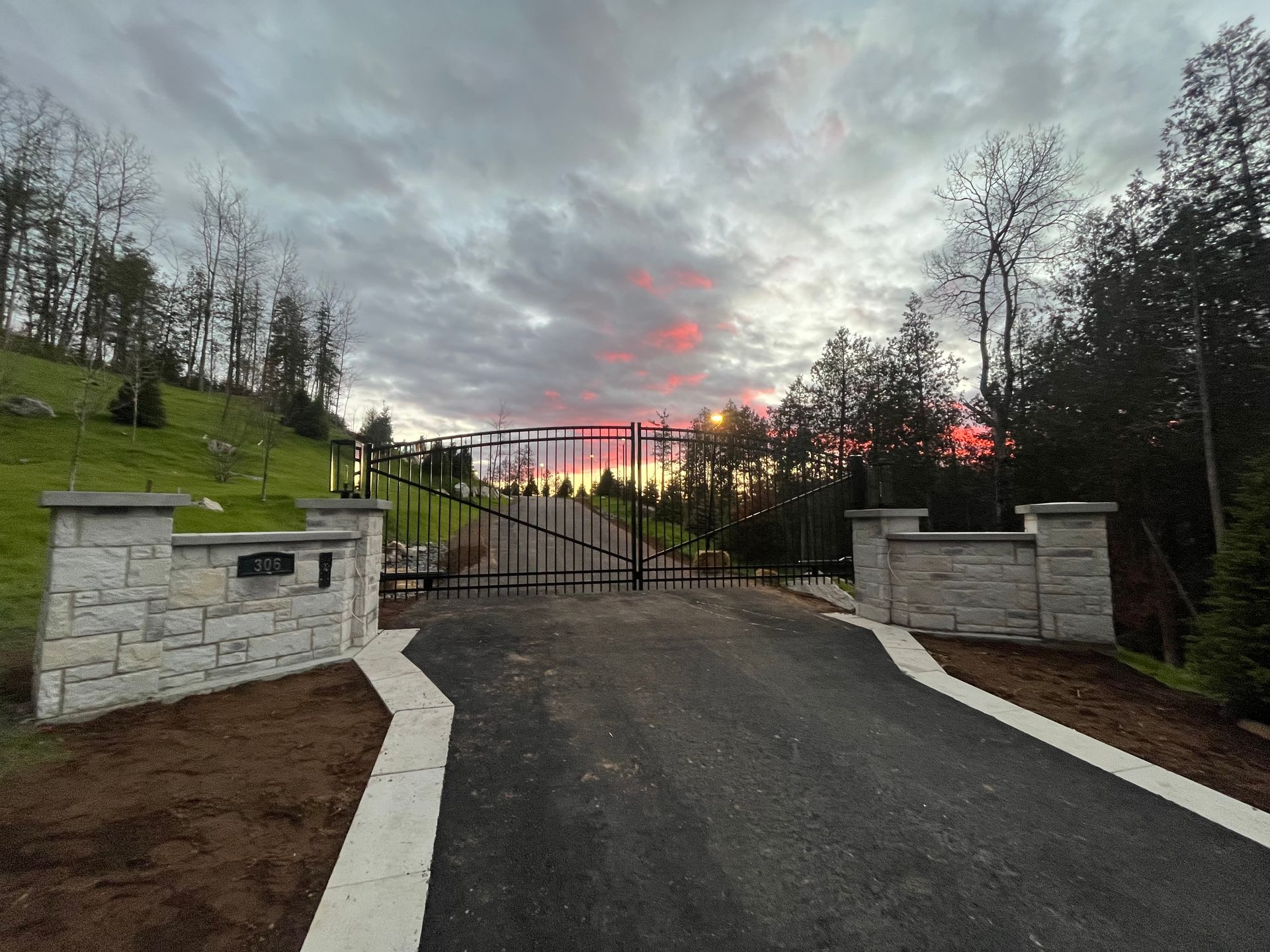 Une allée avec un portail et un coucher de soleil en arrière-plan