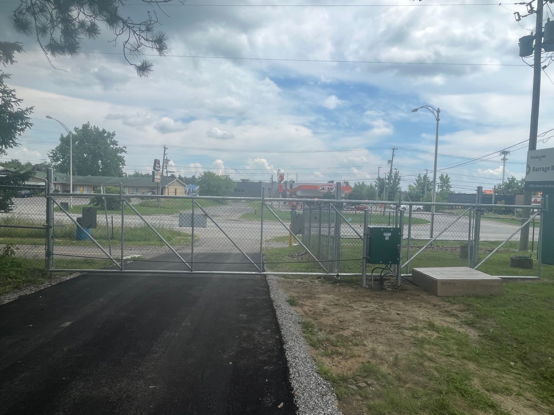 Une porte en métal se trouve sur le bord d'une route.