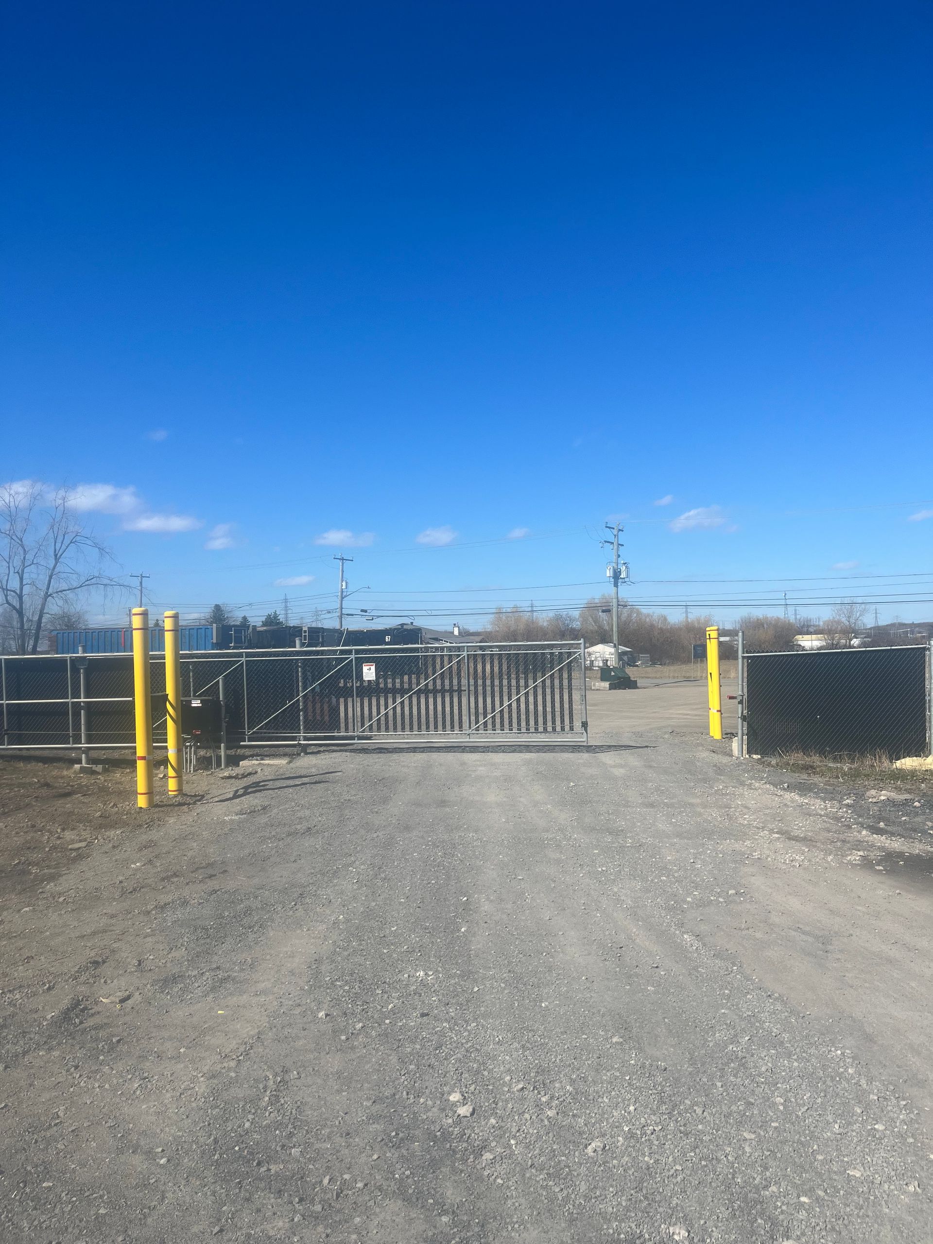 Un chemin de gravier avec une porte au milieu.