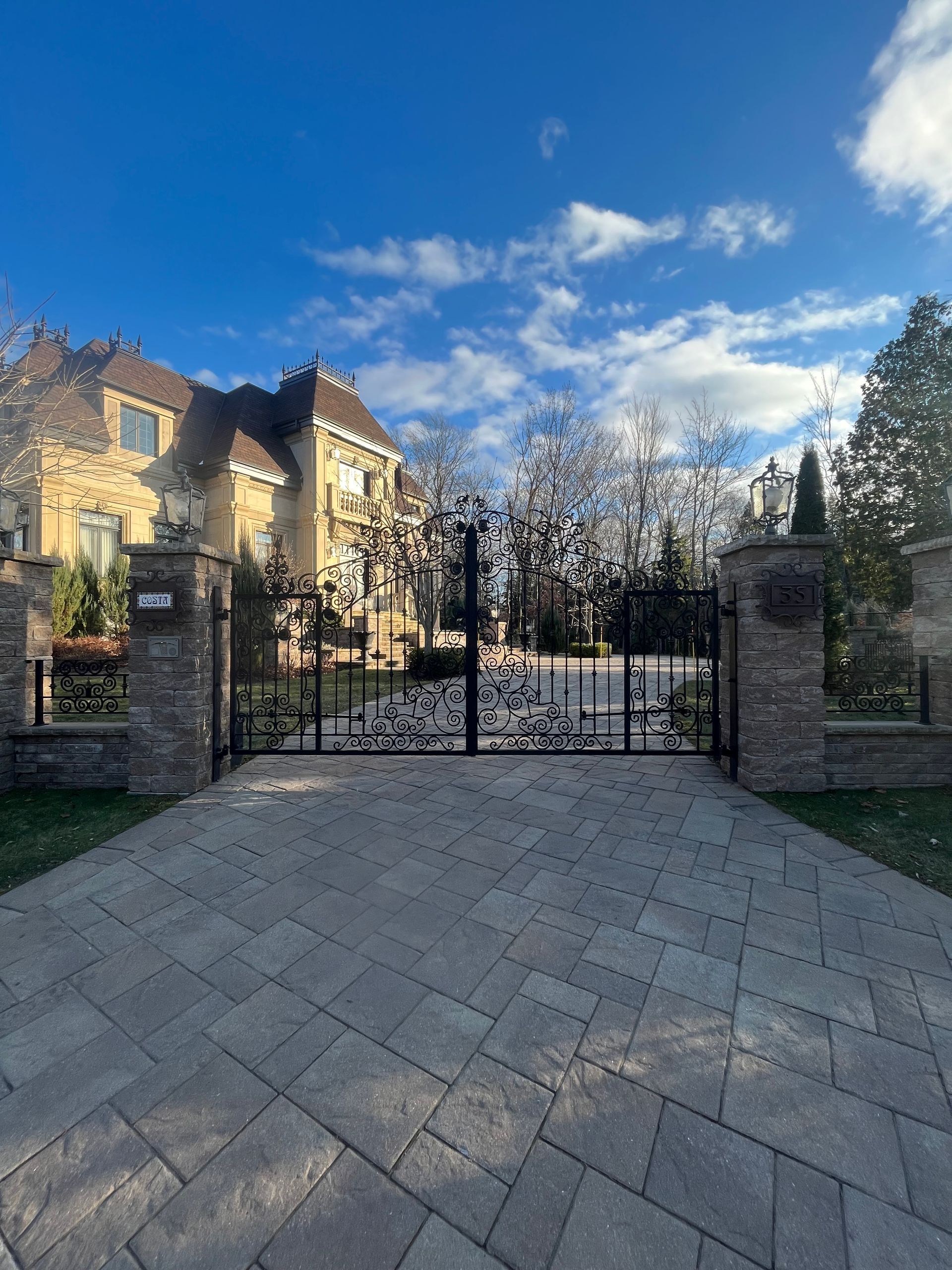 Il y a une grande maison en arrière-plan et un portail au premier plan.