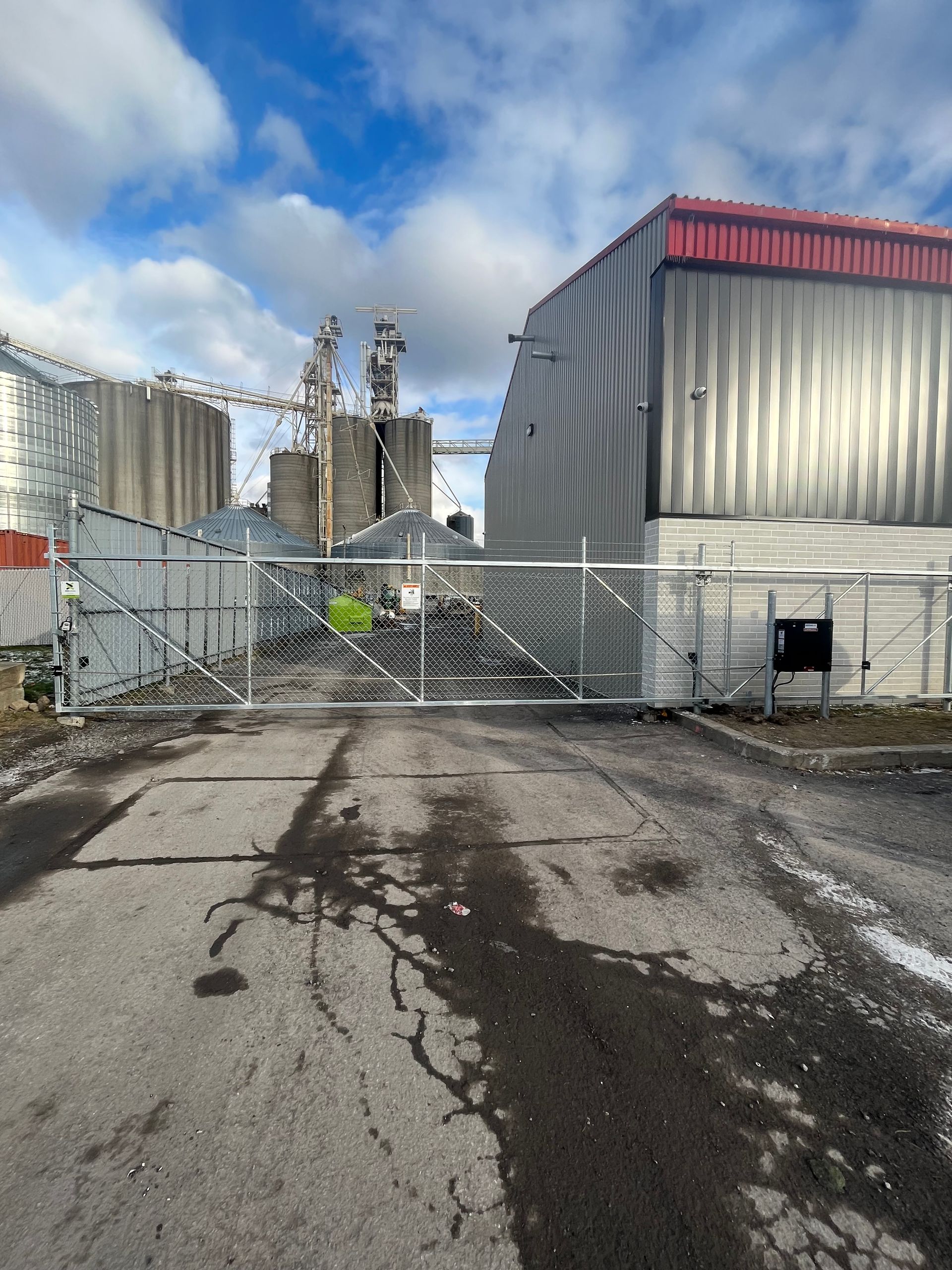 Un grand bâtiment avec un portail coulissant devant lui