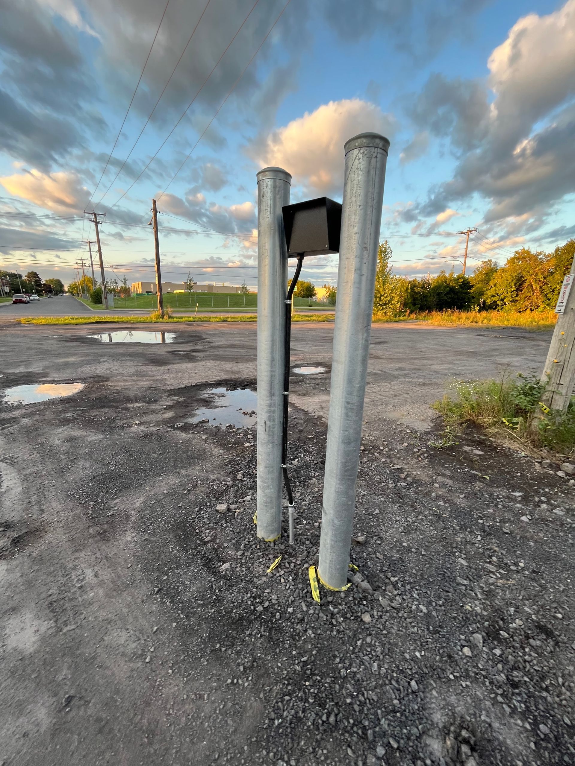 Un poteau métallique avec une lumière attachée dans un parking.