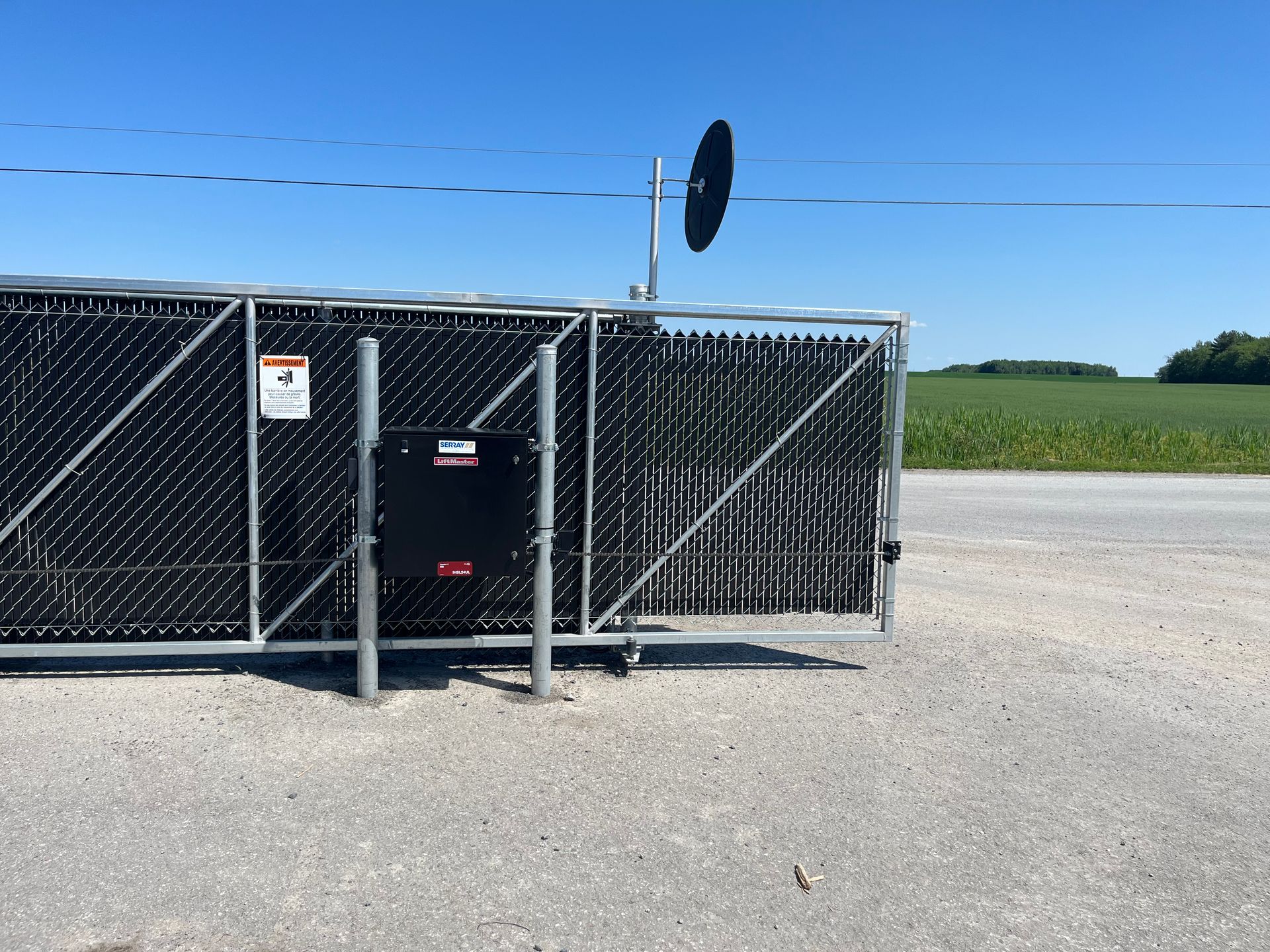 Une clôture grillagée avec une antenne parabolique au-dessus