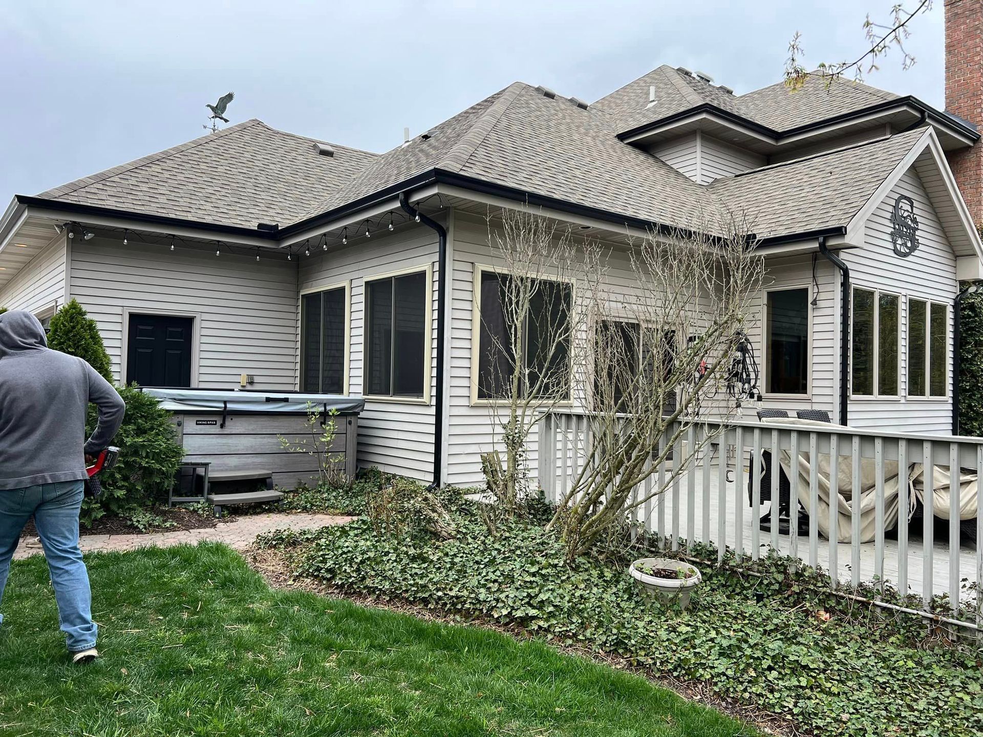 A man is standing in front of a large white house.