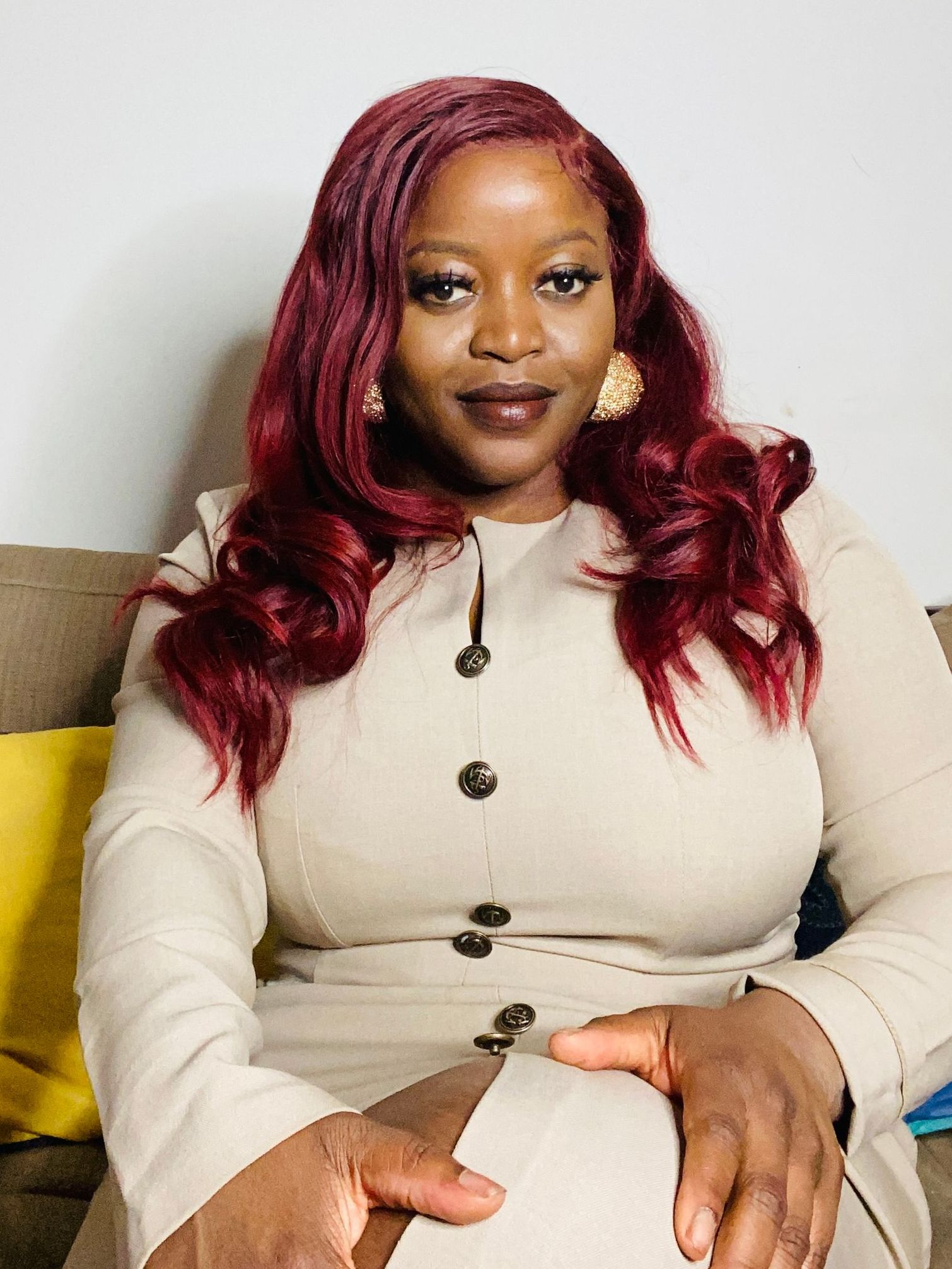 A woman in a red jacket is smiling for the camera