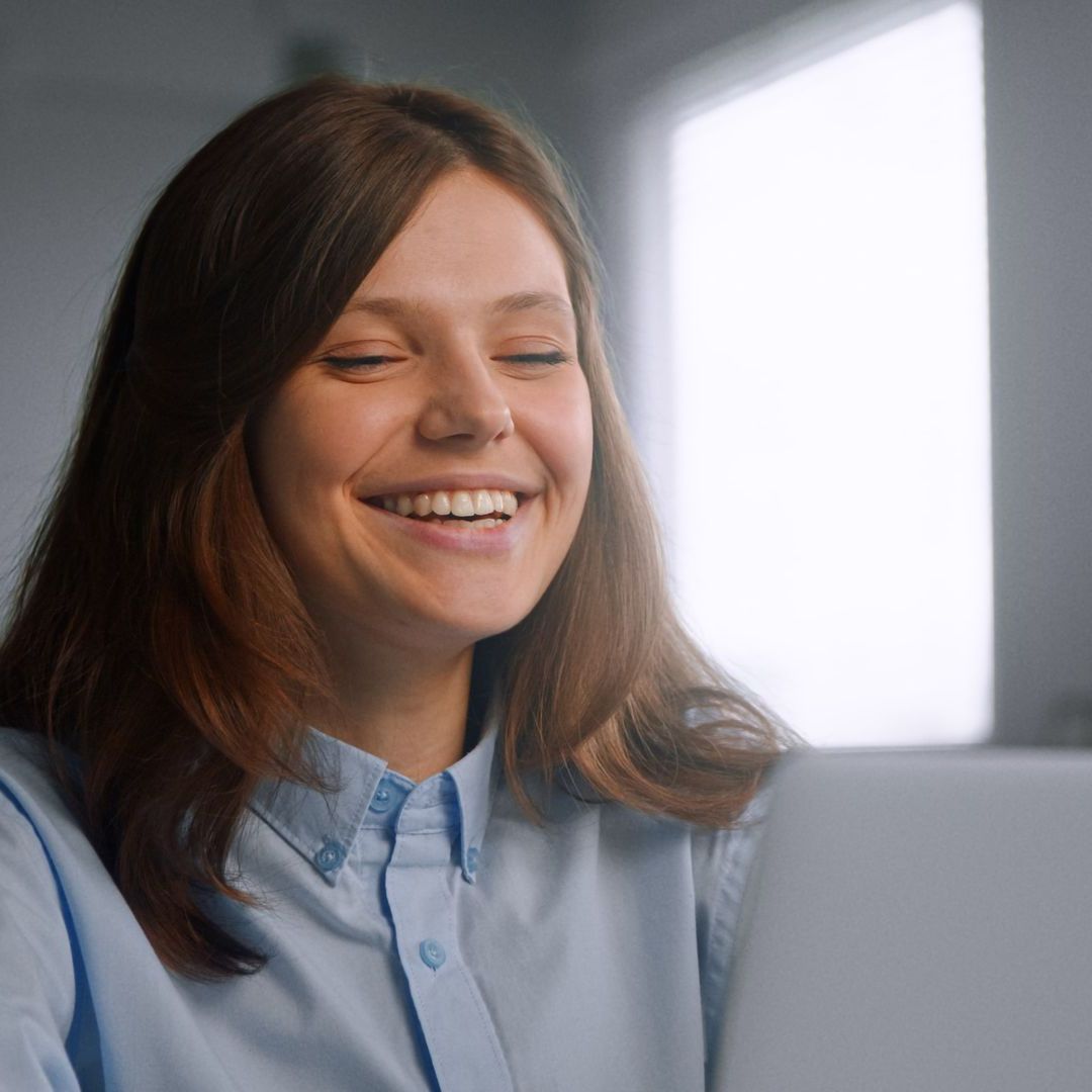 A woman is making a heart shape with her hands.