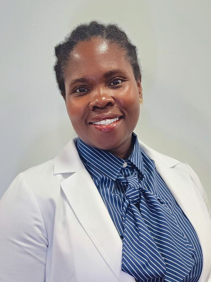 Wendy Akoh Brefo with a blue striped top and a white lab coat is smiling for the camera