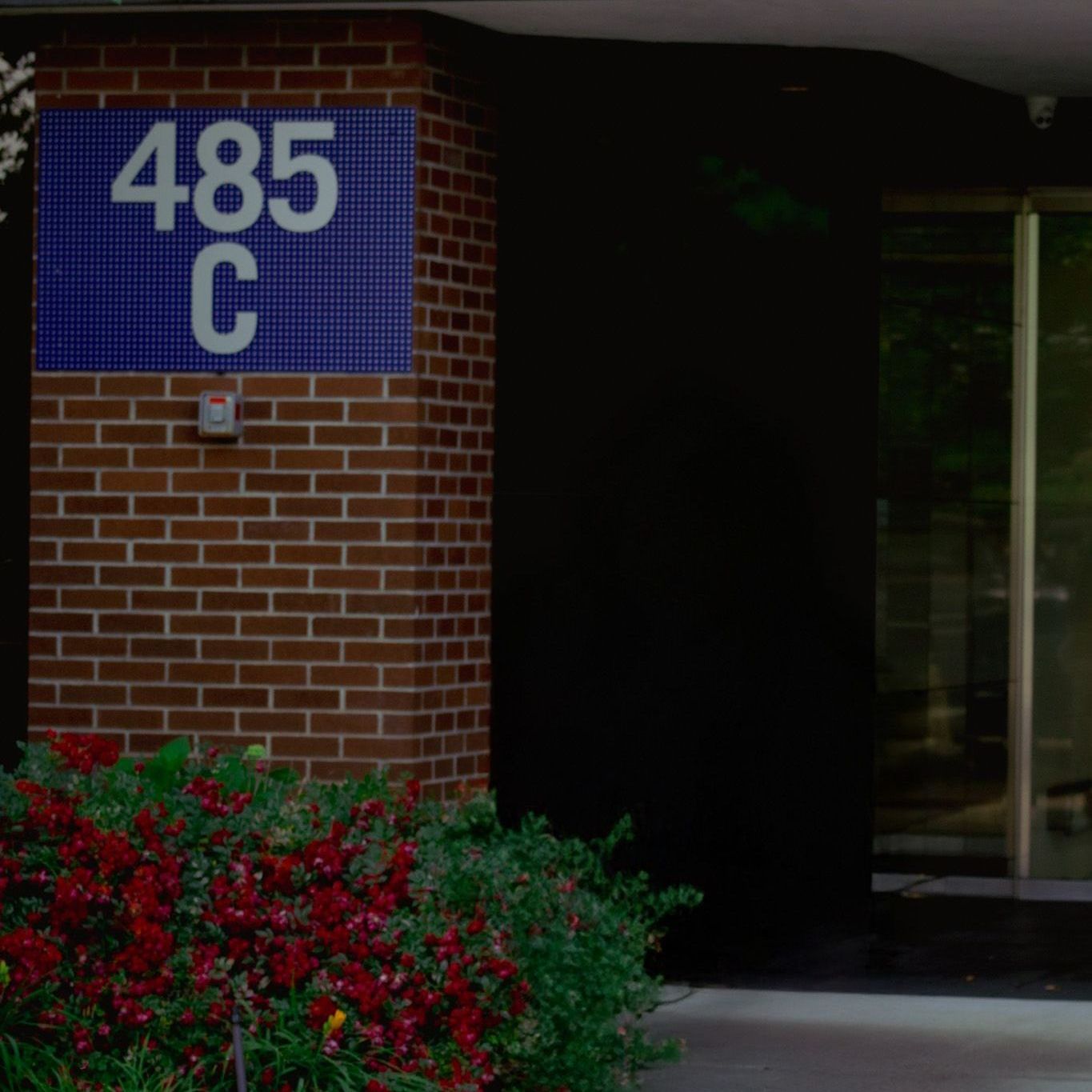 A brick building with a blue sign that says 485 c