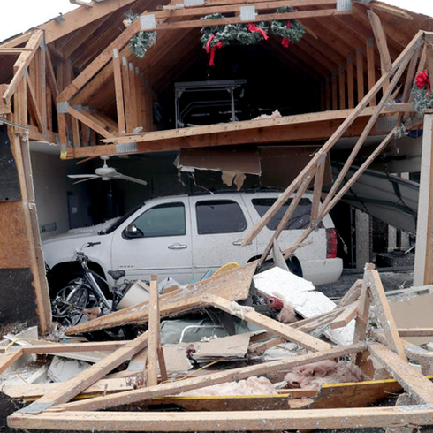 A white suv is parked in a garage that has been demolished