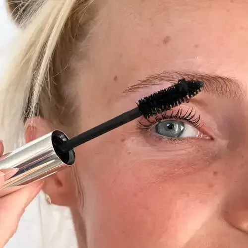 Un primer plano del rostro de una mujer con ojos azules y pecas.