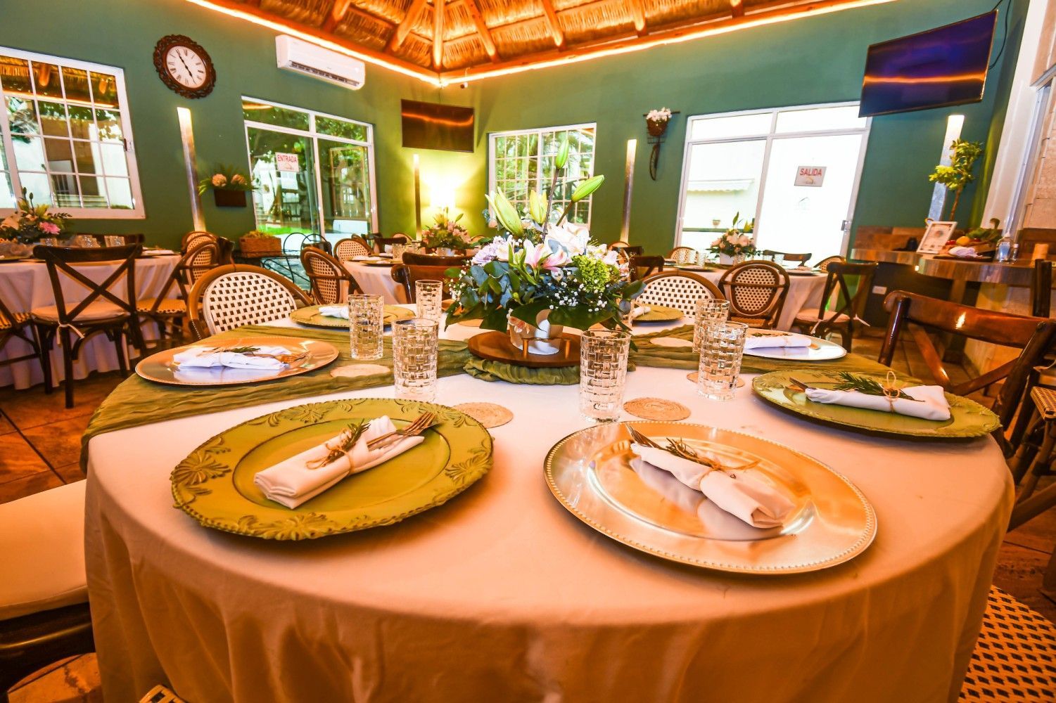 A round table with plates and glasses on it in a restaurant.