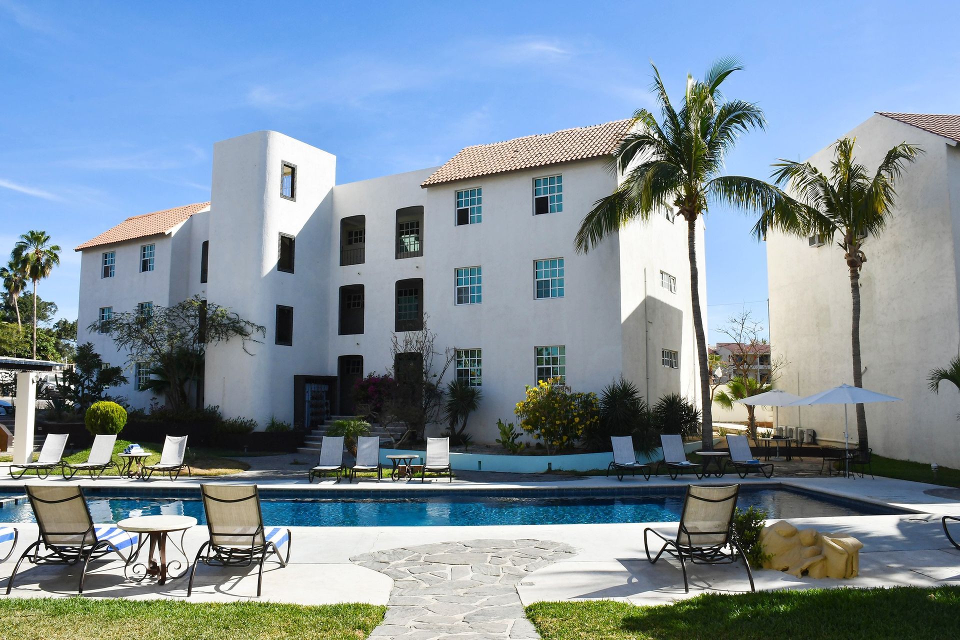A large white building with a swimming pool in front of it