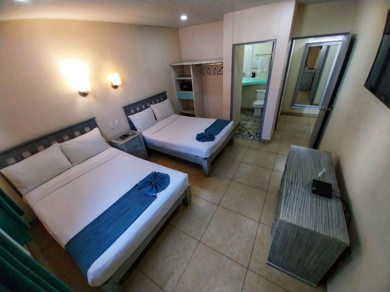 A hotel room with two beds and a dresser