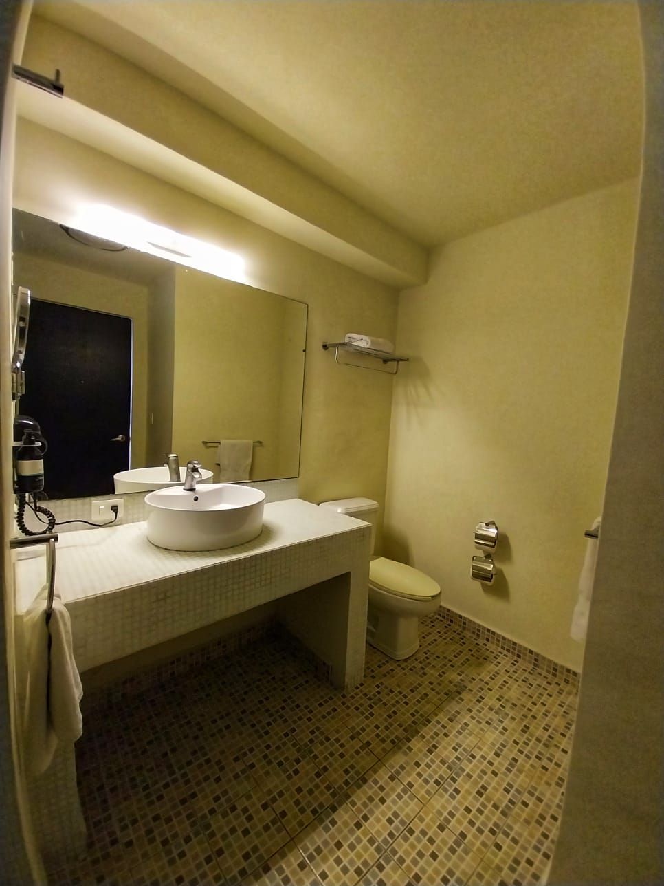 A bathroom with a sink toilet and mirror