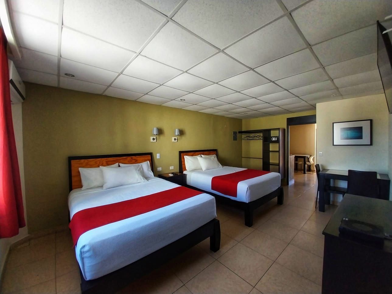 A hotel room with two beds and a desk