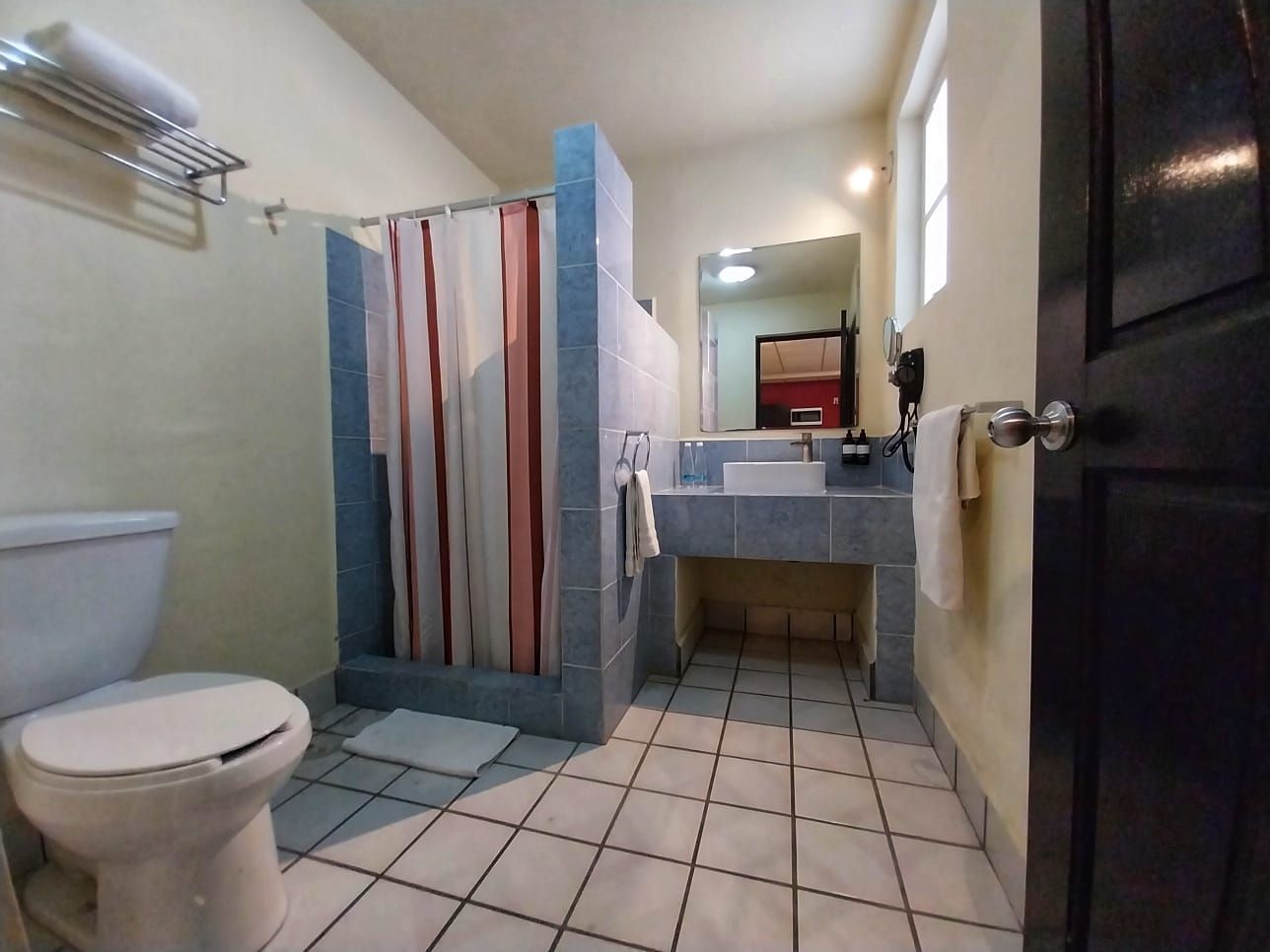 A bathroom with a toilet a sink and a shower