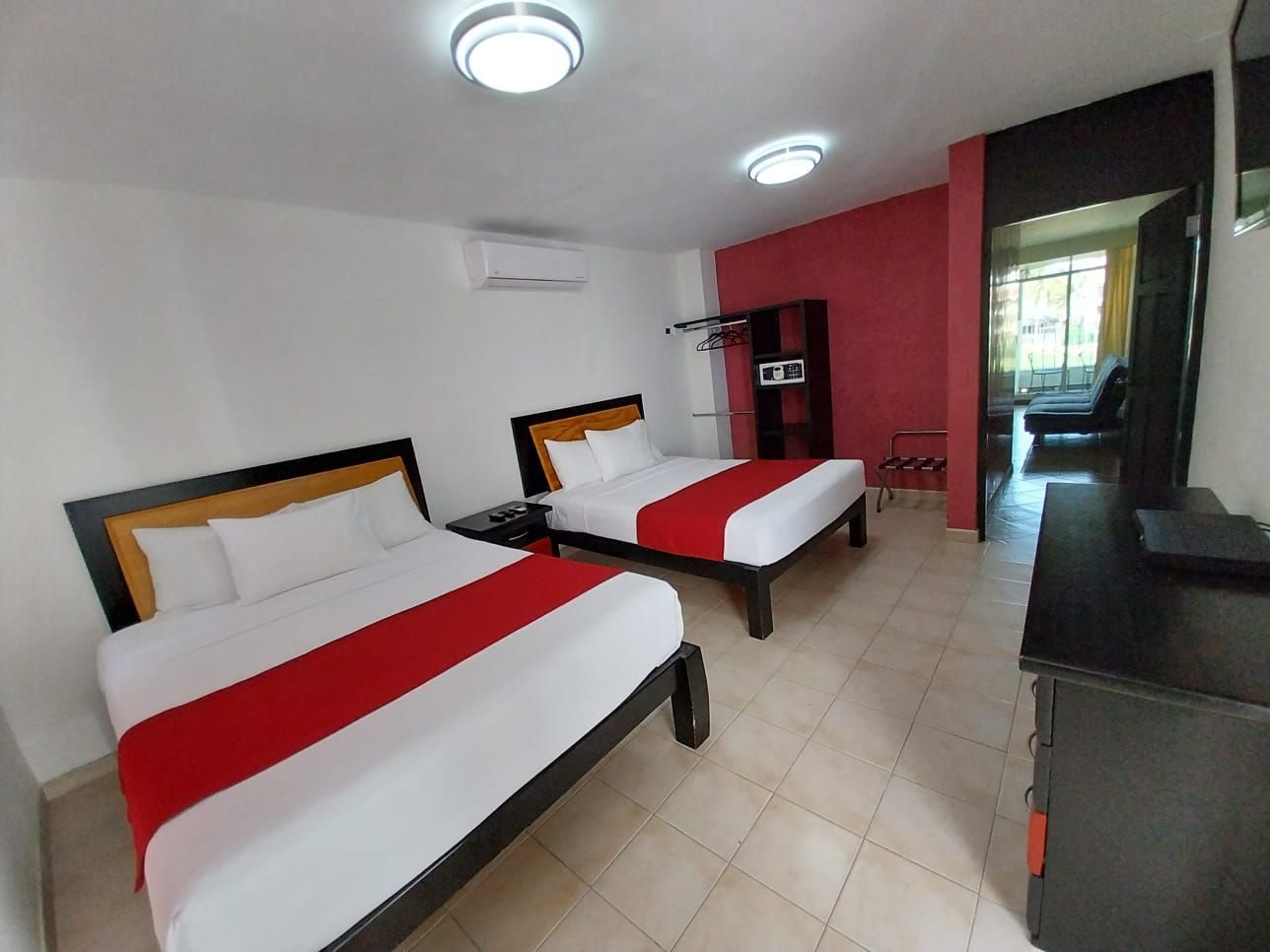 A hotel room with two beds and a dresser