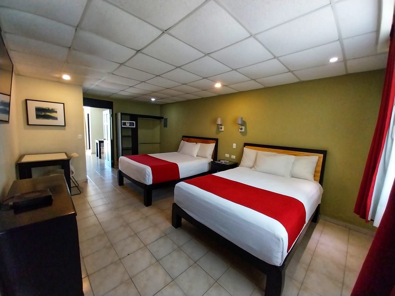 A hotel room with two beds and a dresser