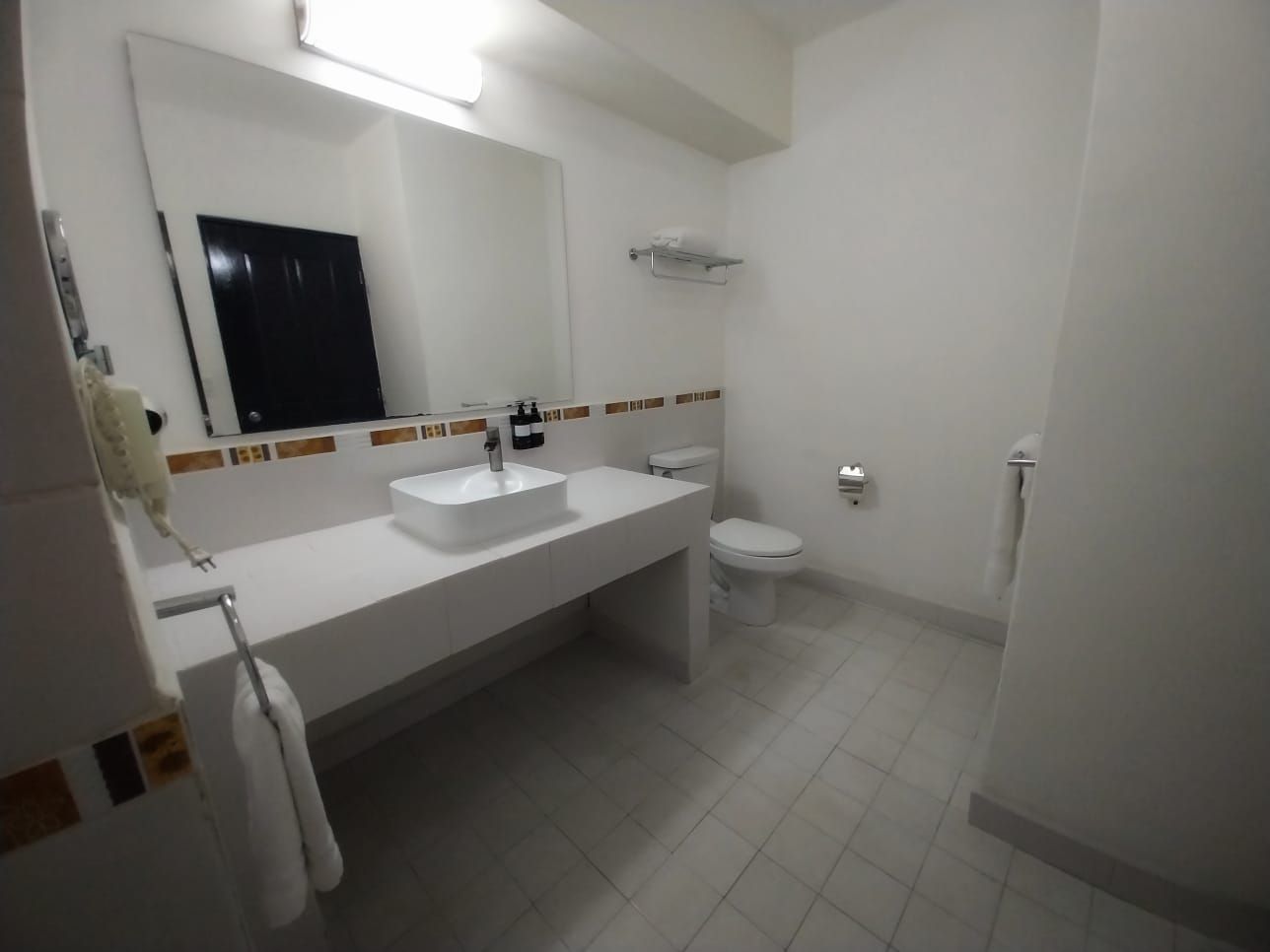 A bathroom with a sink , toilet and mirror.
