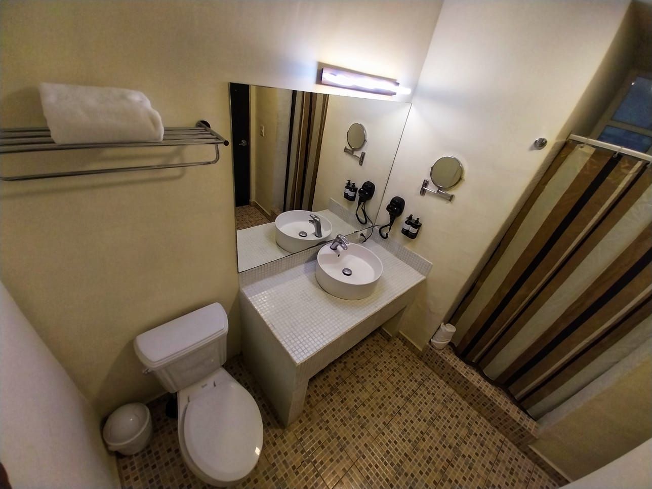 A bathroom with a toilet , sink and mirror