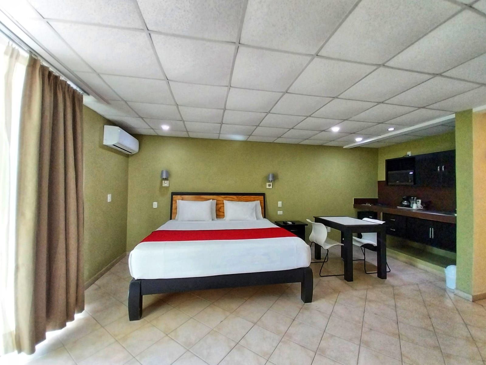 A hotel room with a large bed and a table