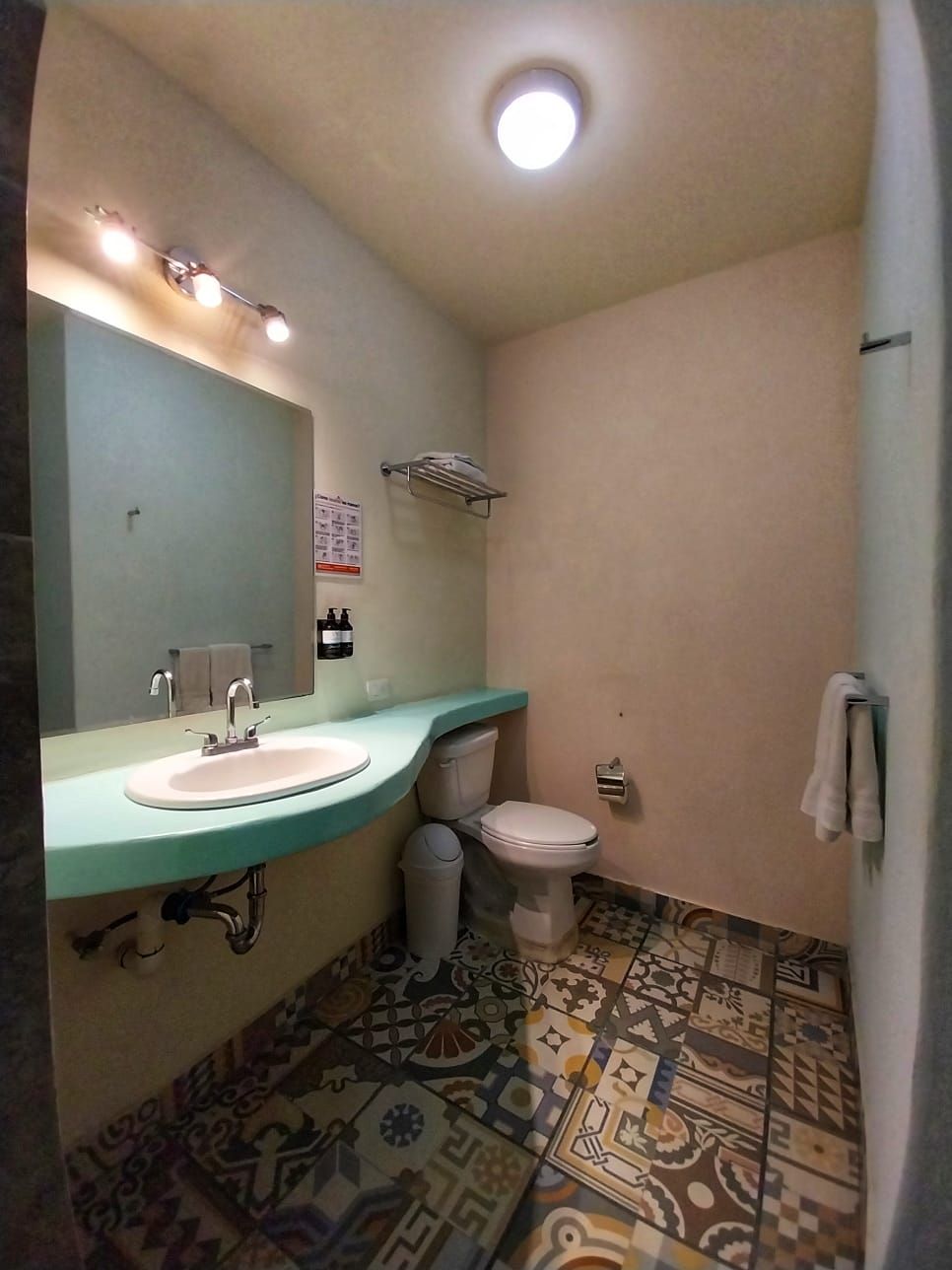 A bathroom with a sink , toilet and mirror.