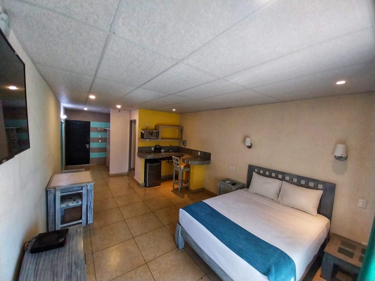 A hotel room with a king size bed and a flat screen tv