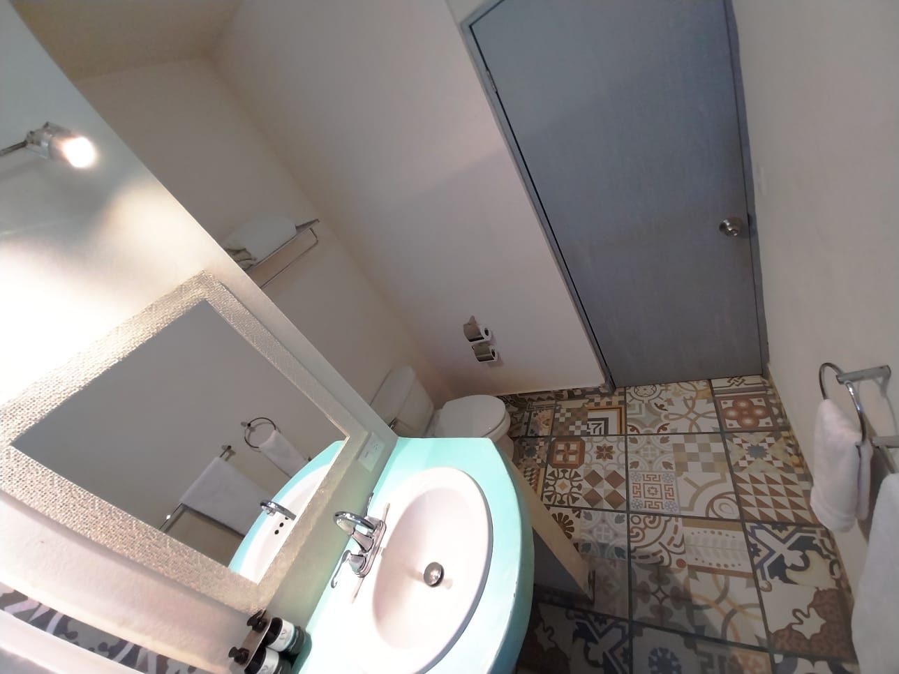 A bathroom with a sink a toilet and a mirror