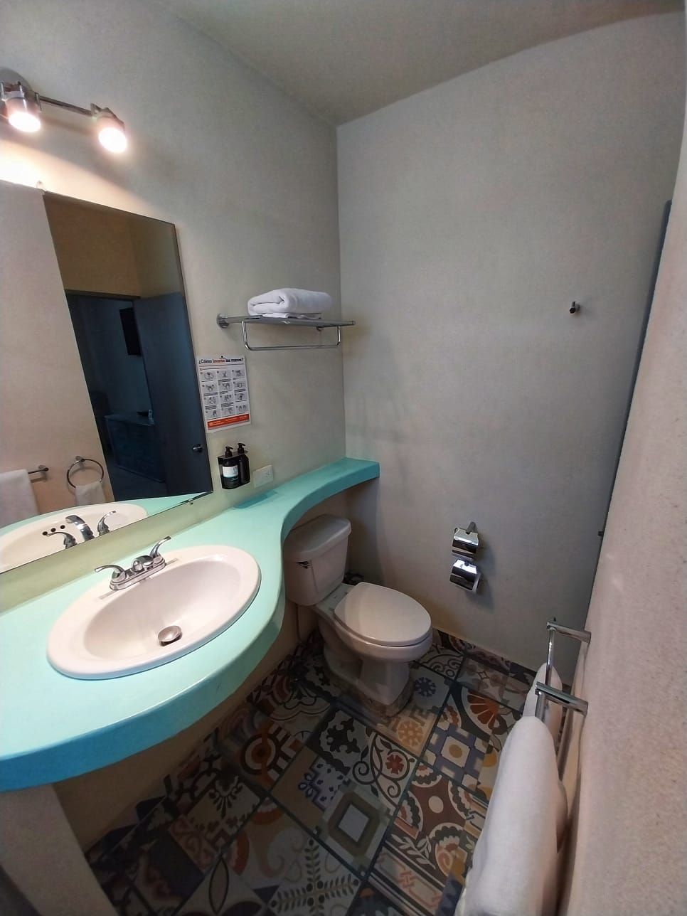 A bathroom with a sink , toilet and mirror.