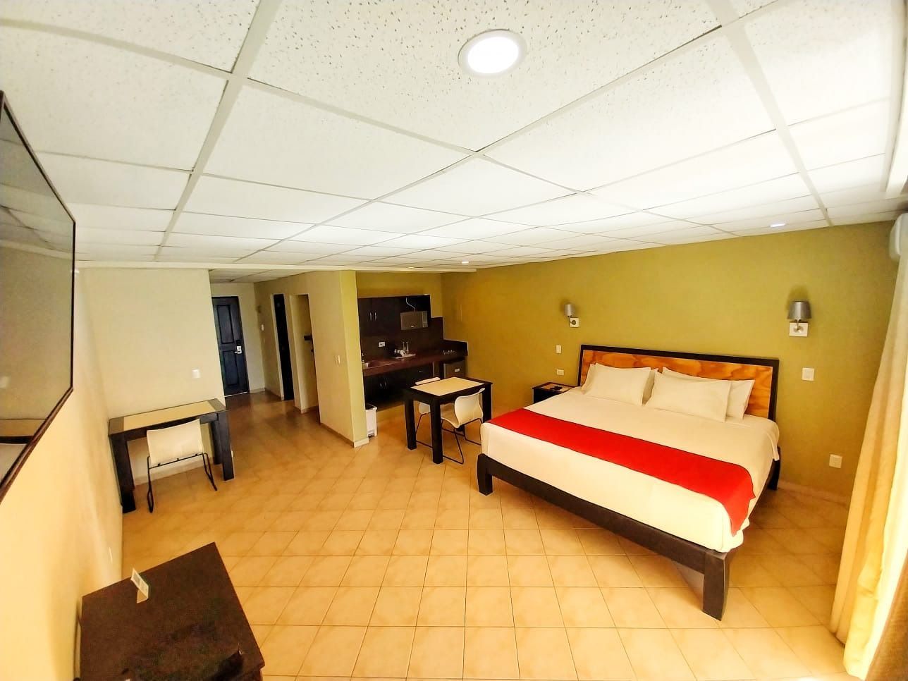 A hotel room with a large bed and a desk