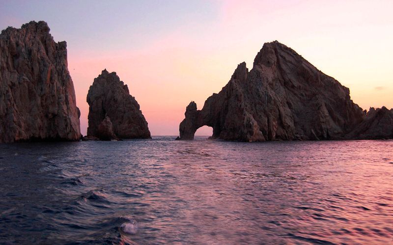 A large rock formation in the middle of a body of water