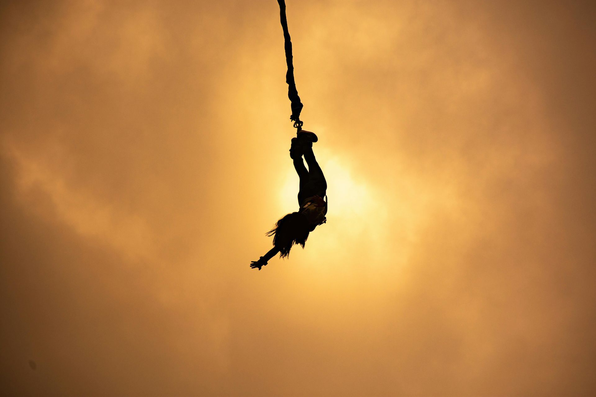 A person is hanging from a bungee cord in the air.