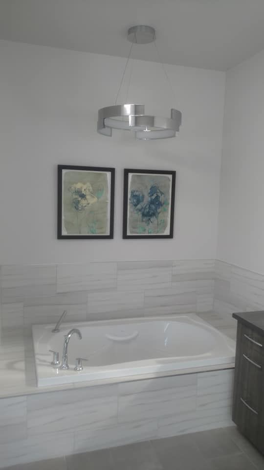 A Bathtub In A Bathroom With Two Paintings On The Wall Above It | Littleton, CO | All Phase Construction Company LLC
