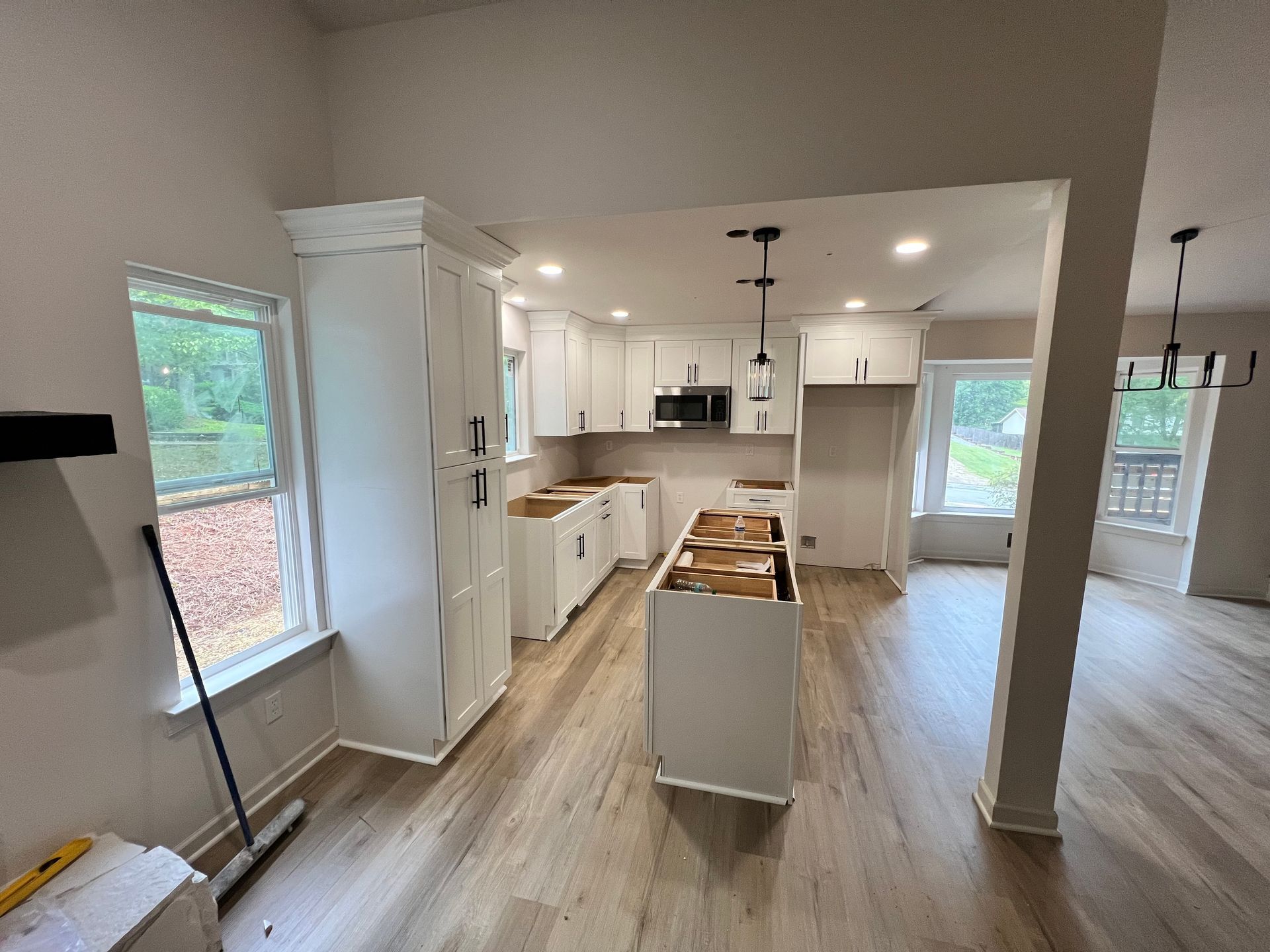 White kitchen renovation with new cabinets, island, and flooring.