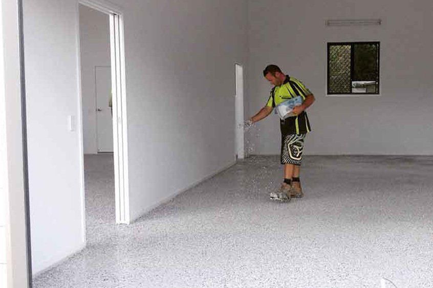 A flooring specialist in Hervey Bay working on epoxy flooring in a garage - Fraser Coast Waterproofing