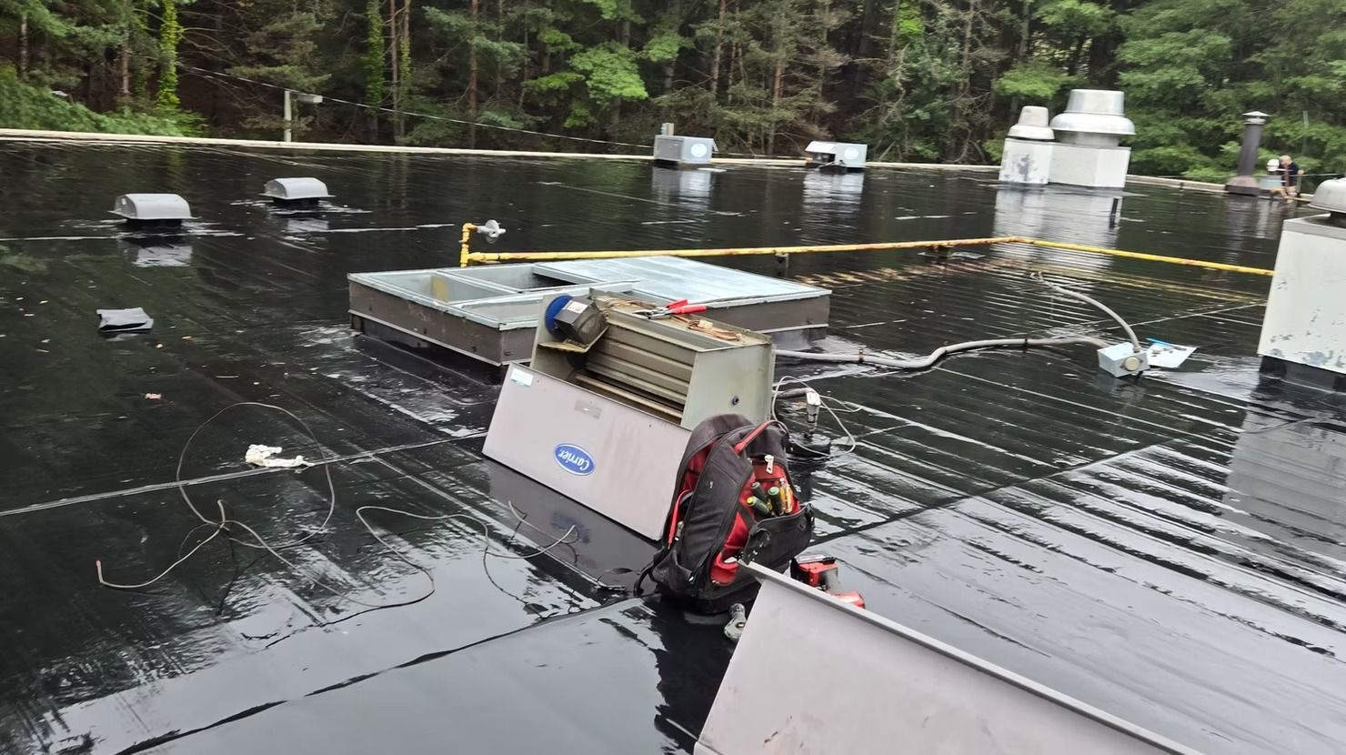A person is standing on a roof in the rain.