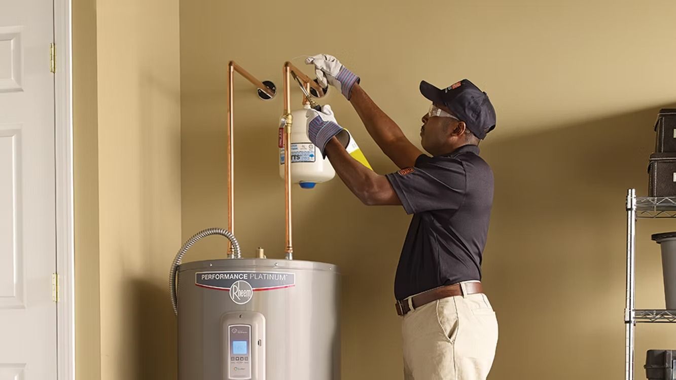 A man is fixing a water heater in a room.
