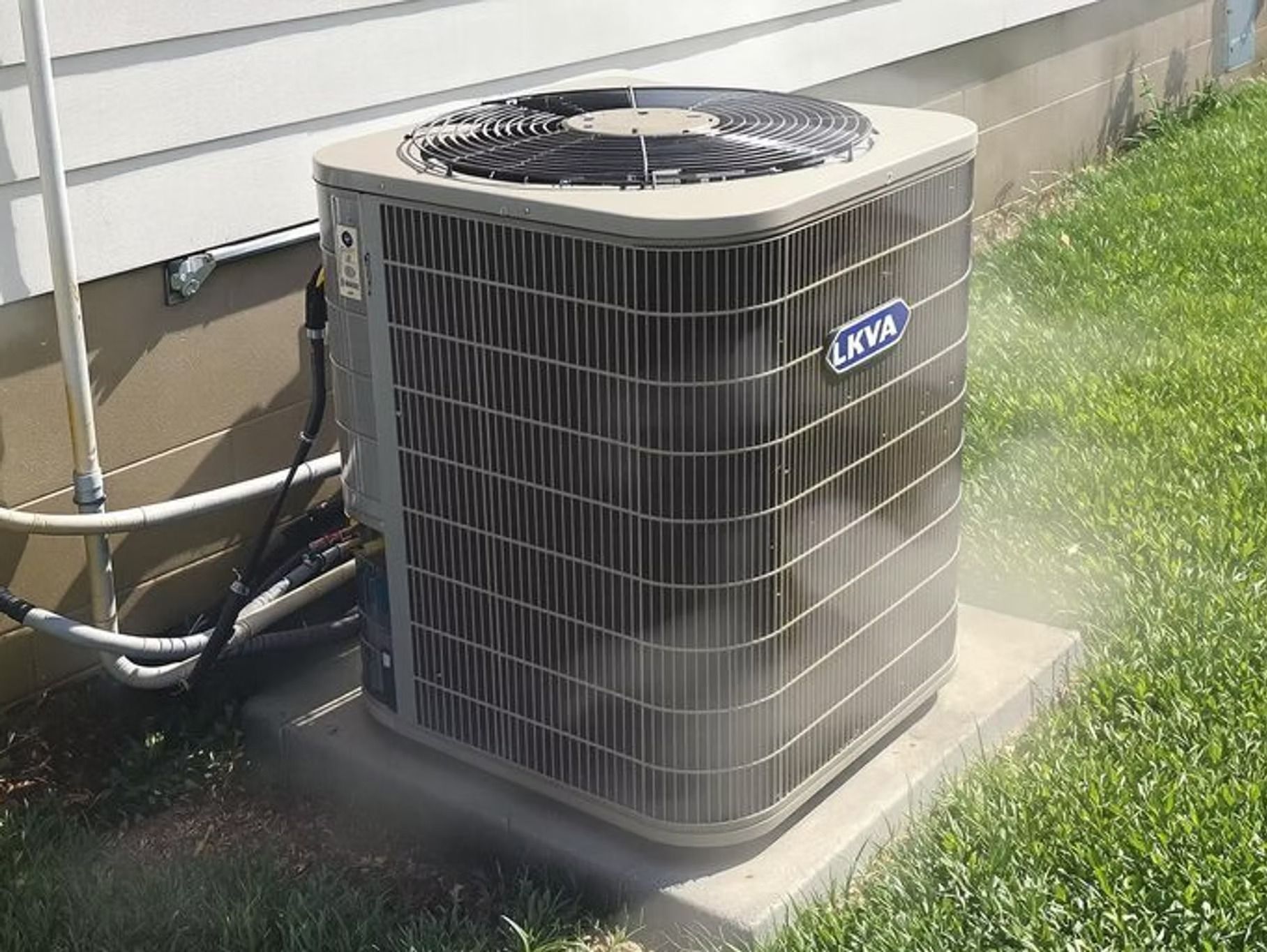 An air conditioner is sitting on the side of a house.