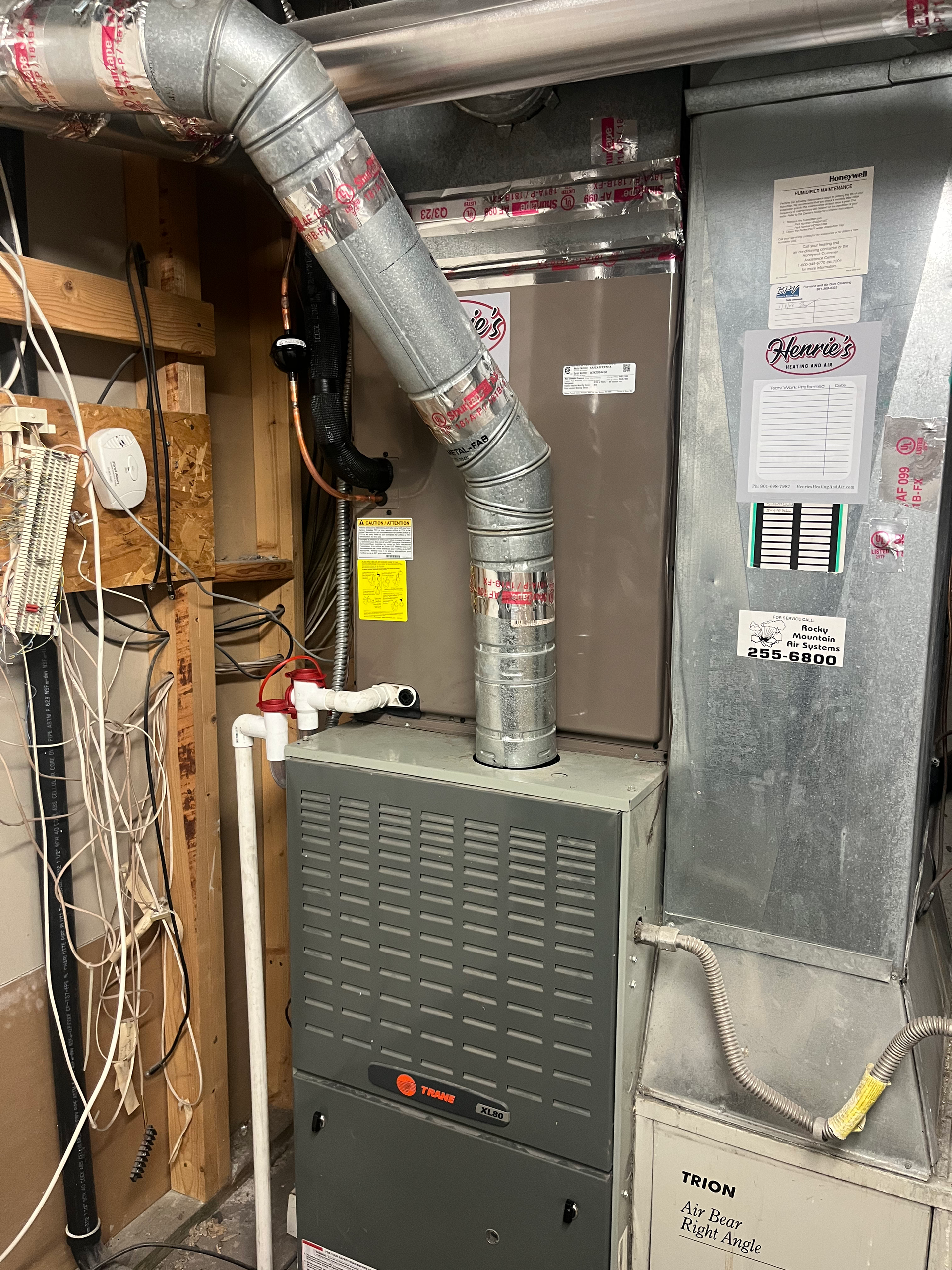 Furnace in a basement. Ductwork and gas line visible. Gray metal and insulation.