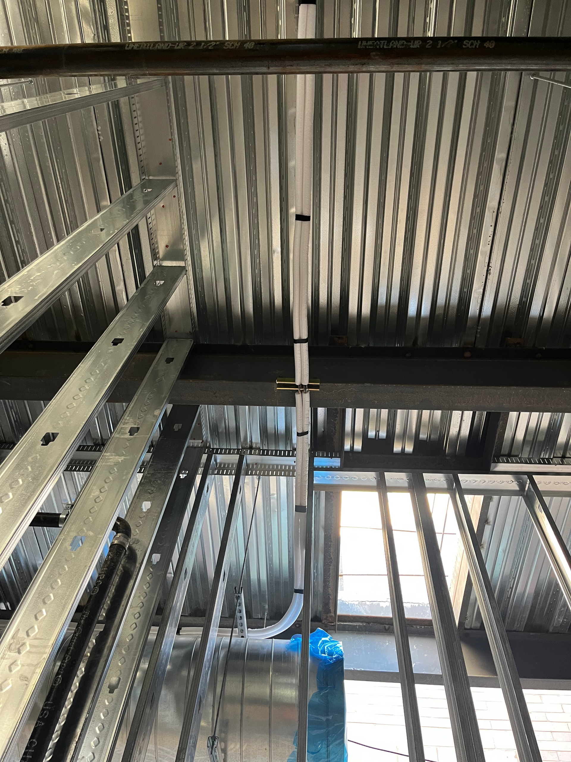 Metal building frame under construction with corrugated metal decking.