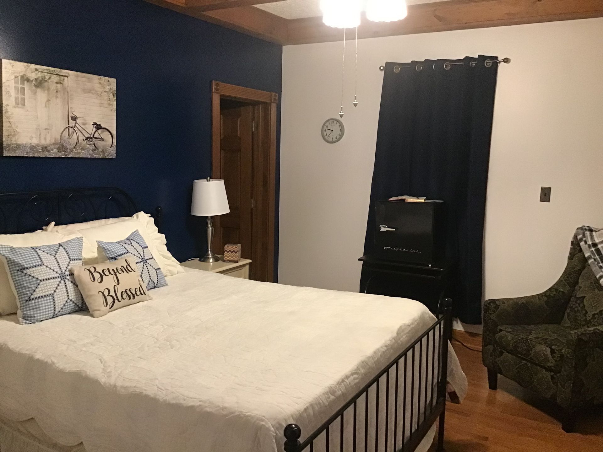 A bedroom with a bed , chair , lamp and television.