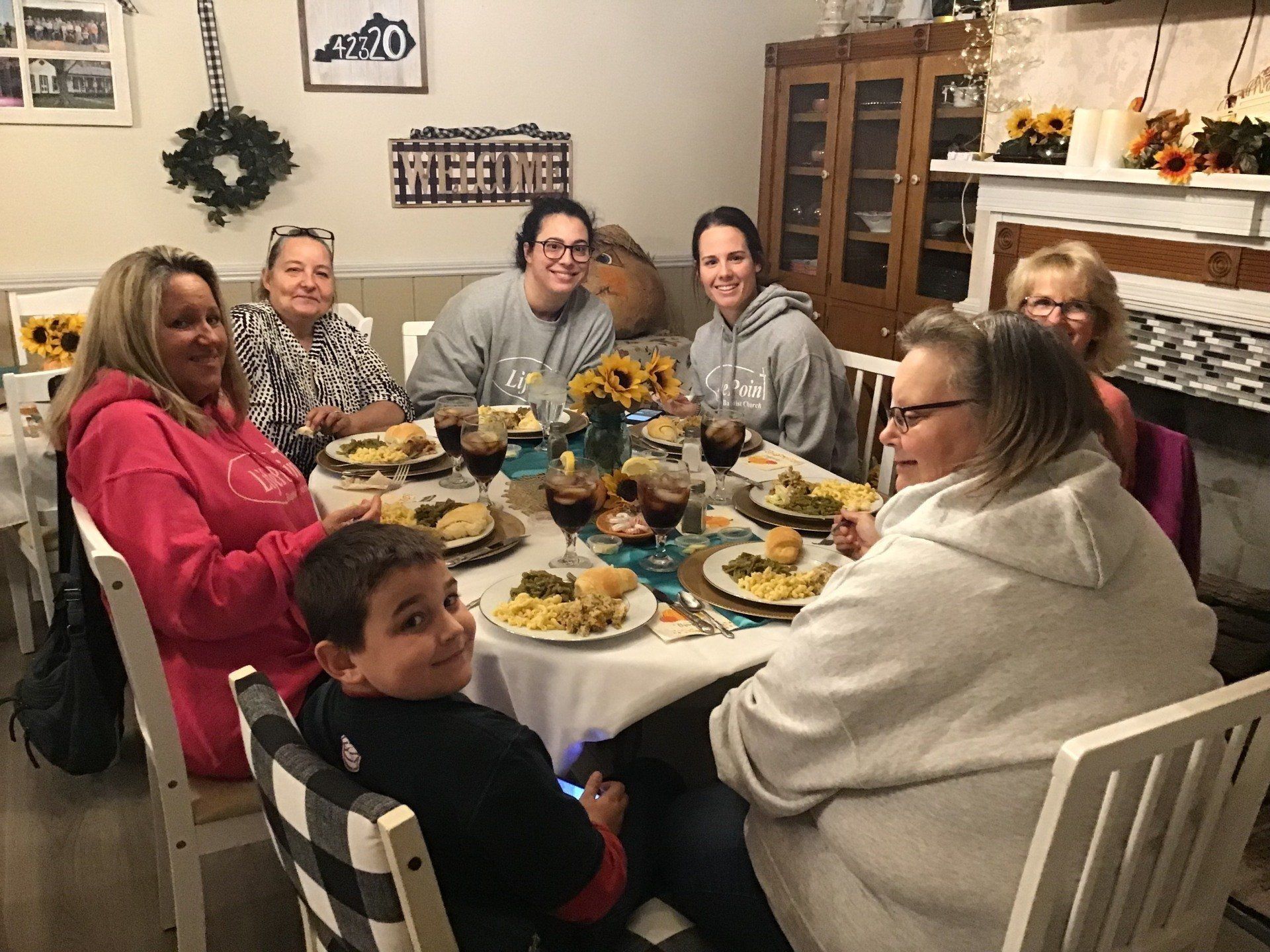 A group of people are sitting around a table eating food.