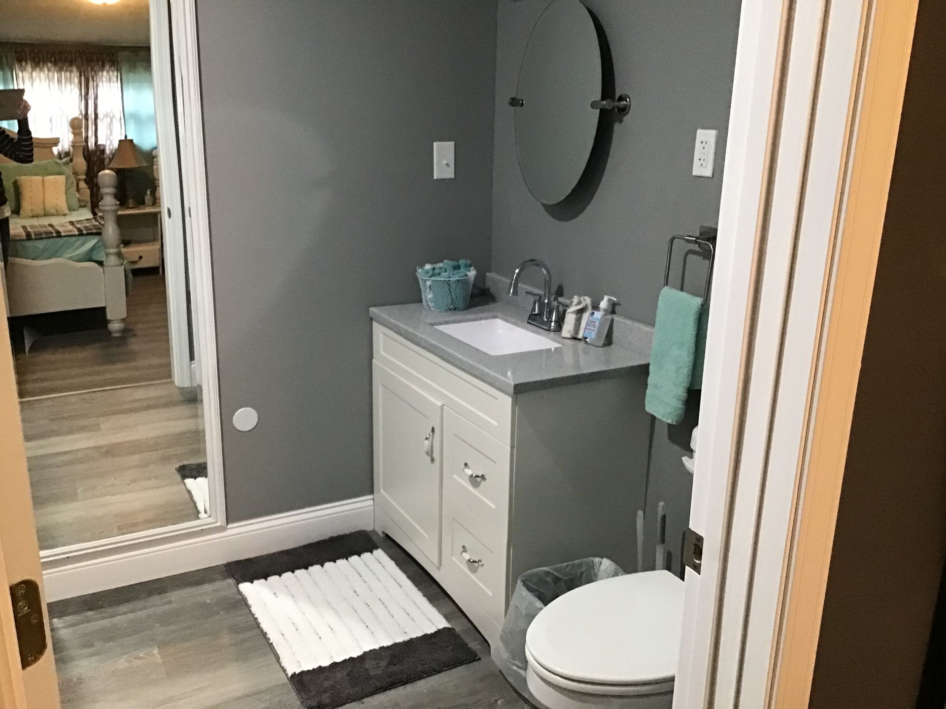 A bathroom with a sink , toilet and mirror.