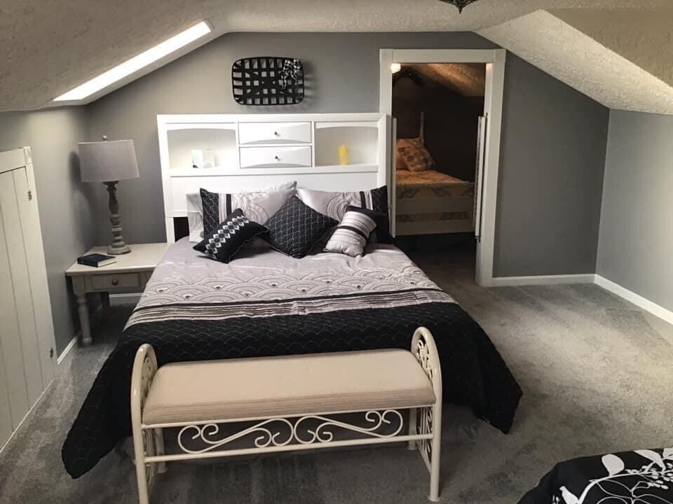 A bedroom with a bed and a bench in it