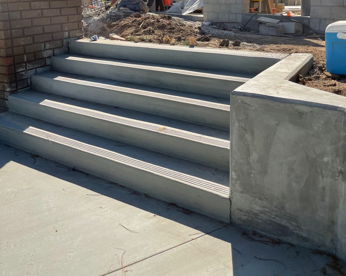 A couple of men are working on a brick walkway.